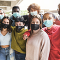 Diverse group of adolescents standing together while wearing face masks. 