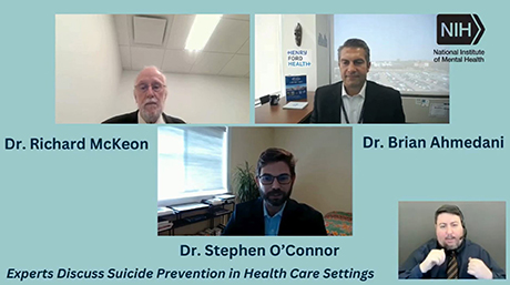 Three experts, Dr. Richard McKeon, Dr. Brian Ahmedani, and Dr. Stephen O'Connor, appear in a video conference discussing suicide prevention in health care settings. The video is hosted by the National Institute of Mental Health (NIH) with a sign language interpreter visible at the bottom right.